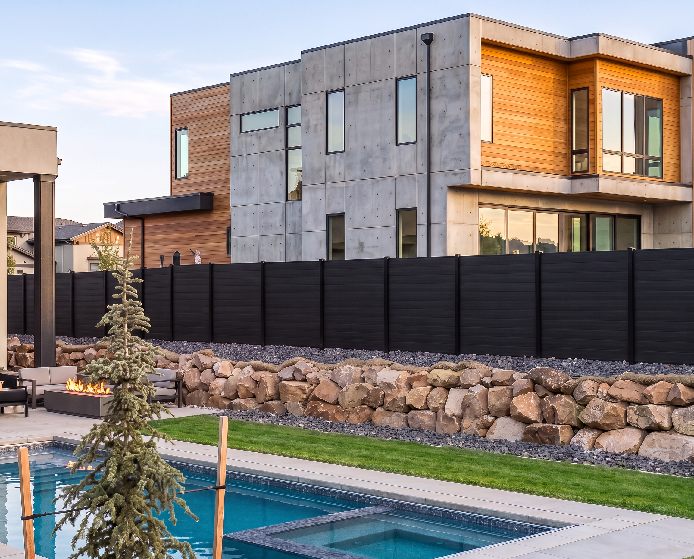 Modern Utah courtyard with retaining stone, pool hardscape, lawn, and composite fencing